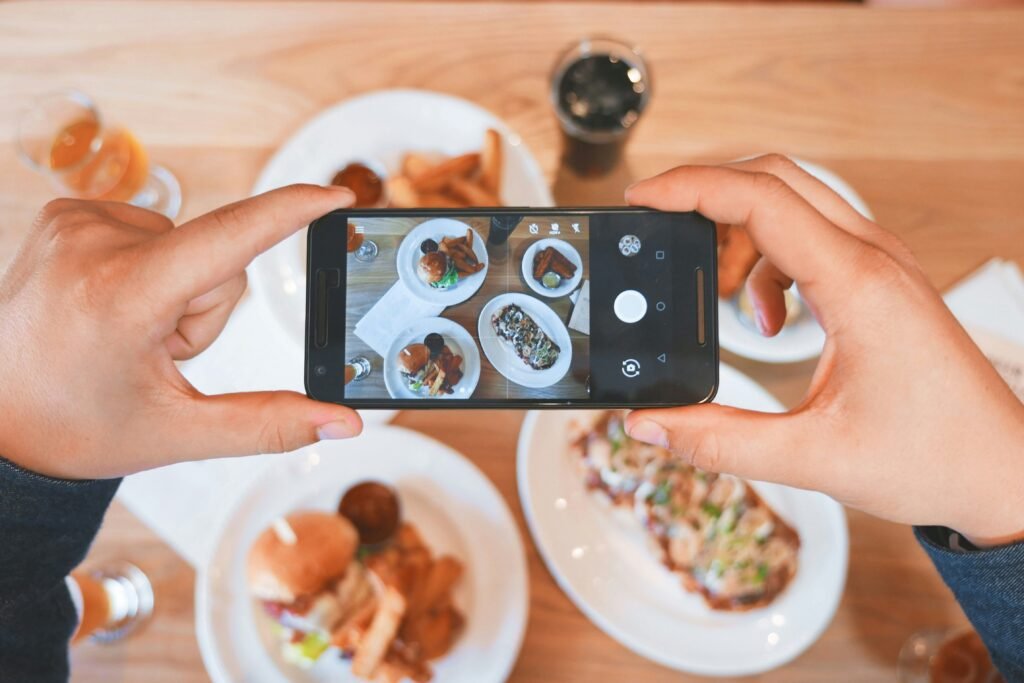 Person taking a photo of food on a table with a smartphone